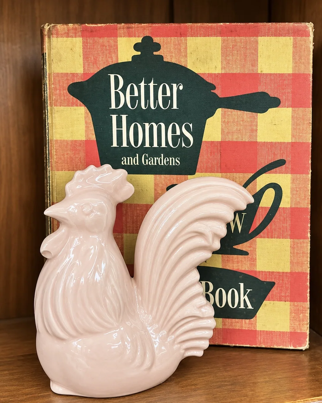 Pink glass rooster with vintage cookbook